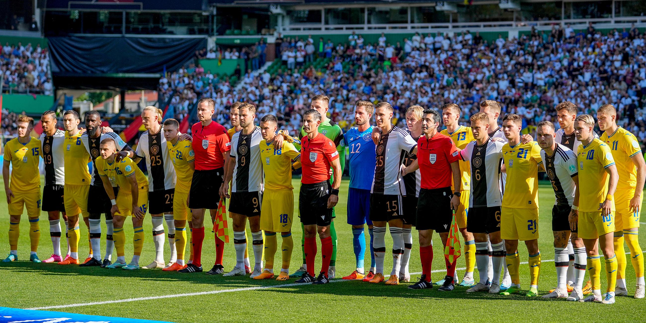 12.06.2023, Bremen: Die ukrainische und die deutsche Mannschaft stehen während eines Freundschaftsspiels zwischen Deutschland und der Ukraine zusammen
