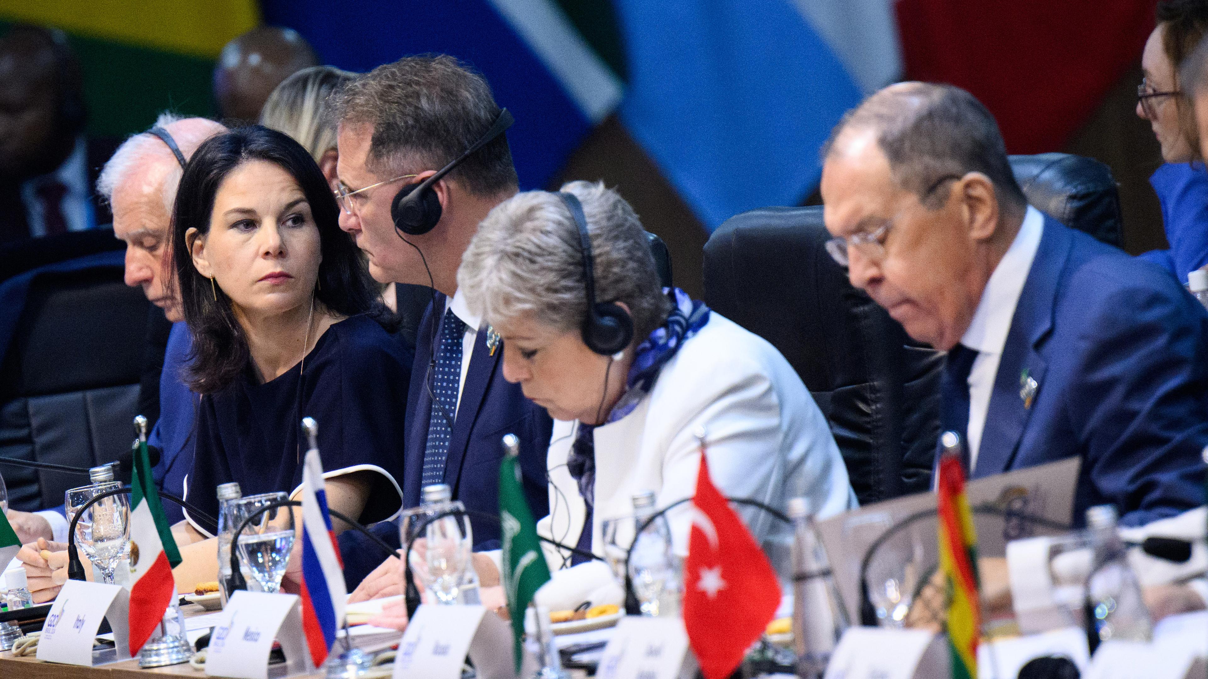 Annalena Baerbock sitzt nur drei Plätze neben Sergej Lawrow, Außenminister von Russland, zu Beginn der ersten Arbeitssitzung des G20-Außenministertreffens in Rio de Janeiro am 21.02.2024.