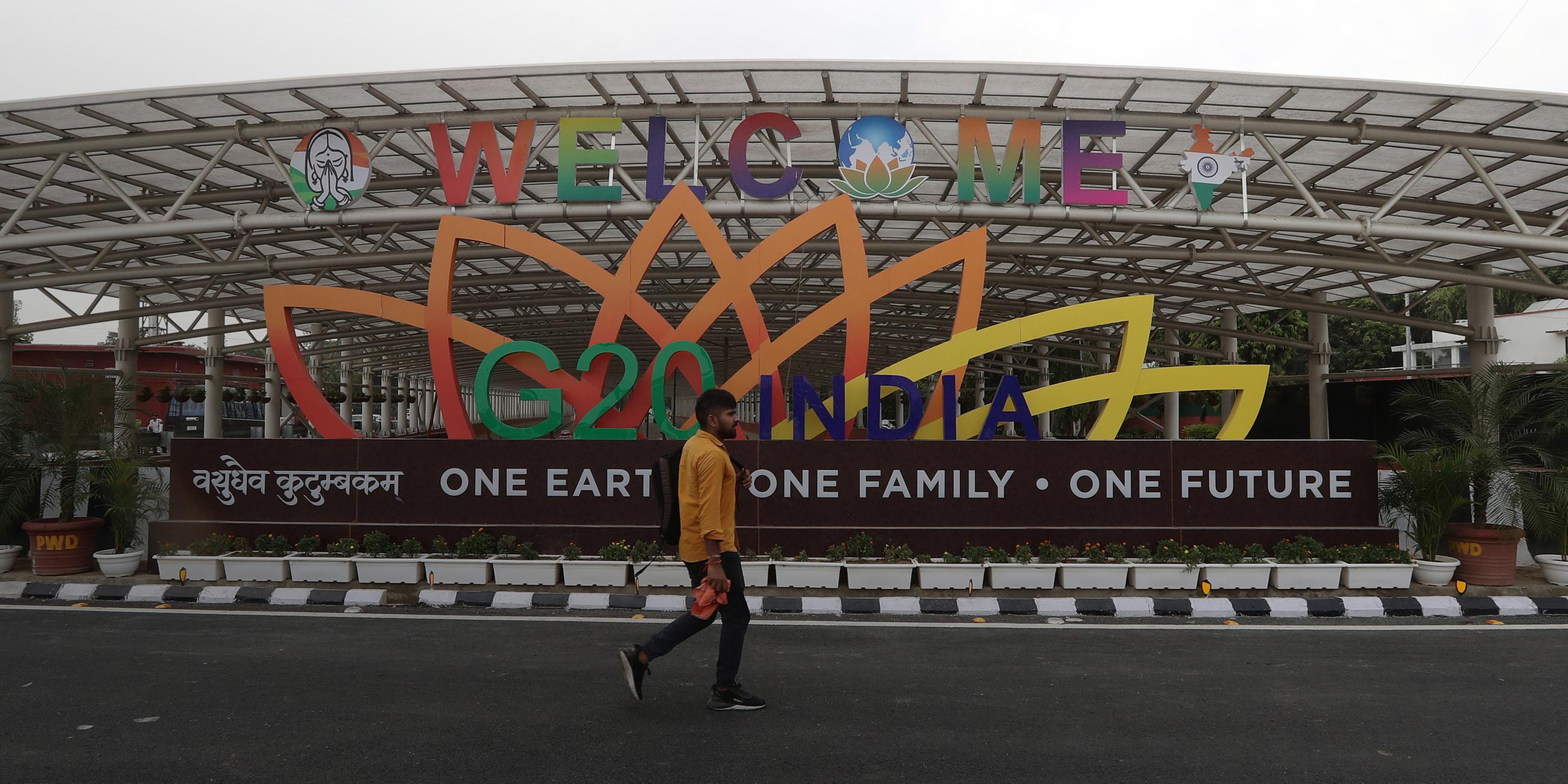 Einheimische laufen am G20-Logo in der Nähe des Veranstaltungsortes des G20-Gipfeltreffens der Staats- und Regierungschefs in Indien vorbei. (31.08.2023)