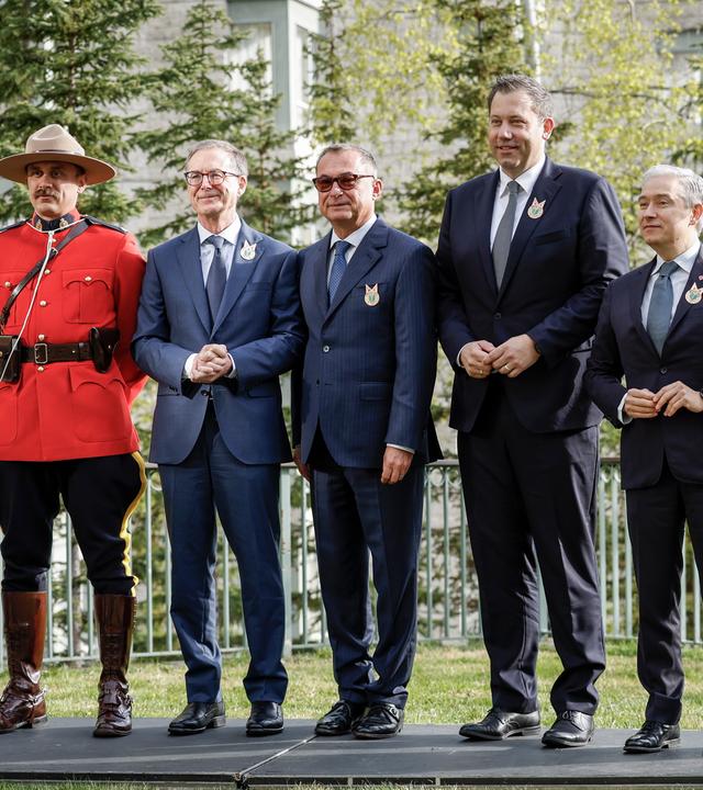 Kanadas Finanzminister Francois-Philippe Champagne (Zweiter von rechts), der deutsche Finanzminister Lars Klingbeil (Dritter von rechts), die Gouverneurin der Bank of Canada Tiff Macklem (Zweite von links) und der deutsche Bundesbankpräsident Dr. Joachim Nagel posieren mit RCMP-Beamten vor dem Treffen der G7-Finanzminister in Banff (Alta), Mittwoch, 21. Mai 2025.