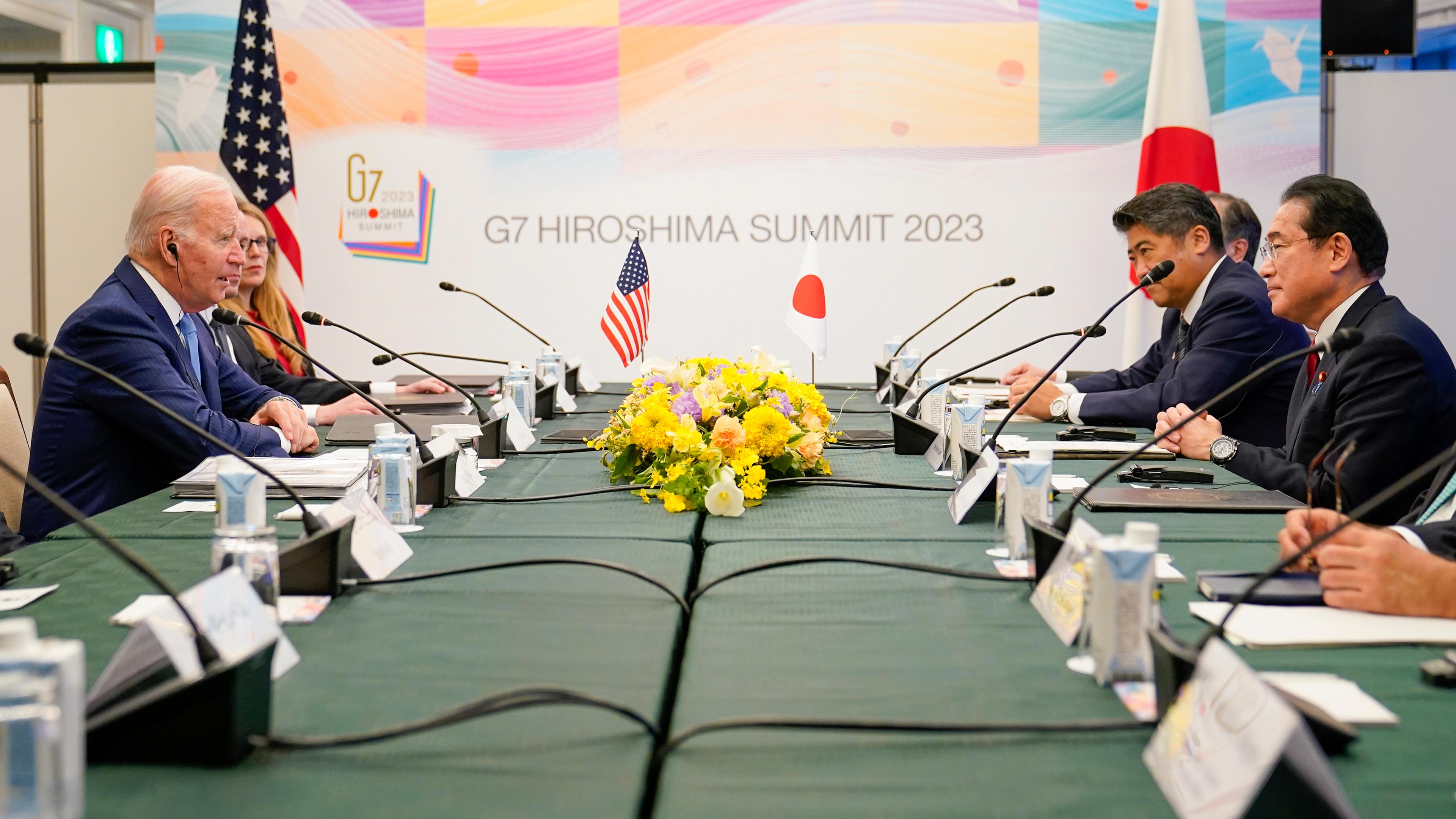Zu sehen ist ene US-amerikanische Delegation mit Präsident Joe Biden im Gespräch mit der japanischen Delegation.