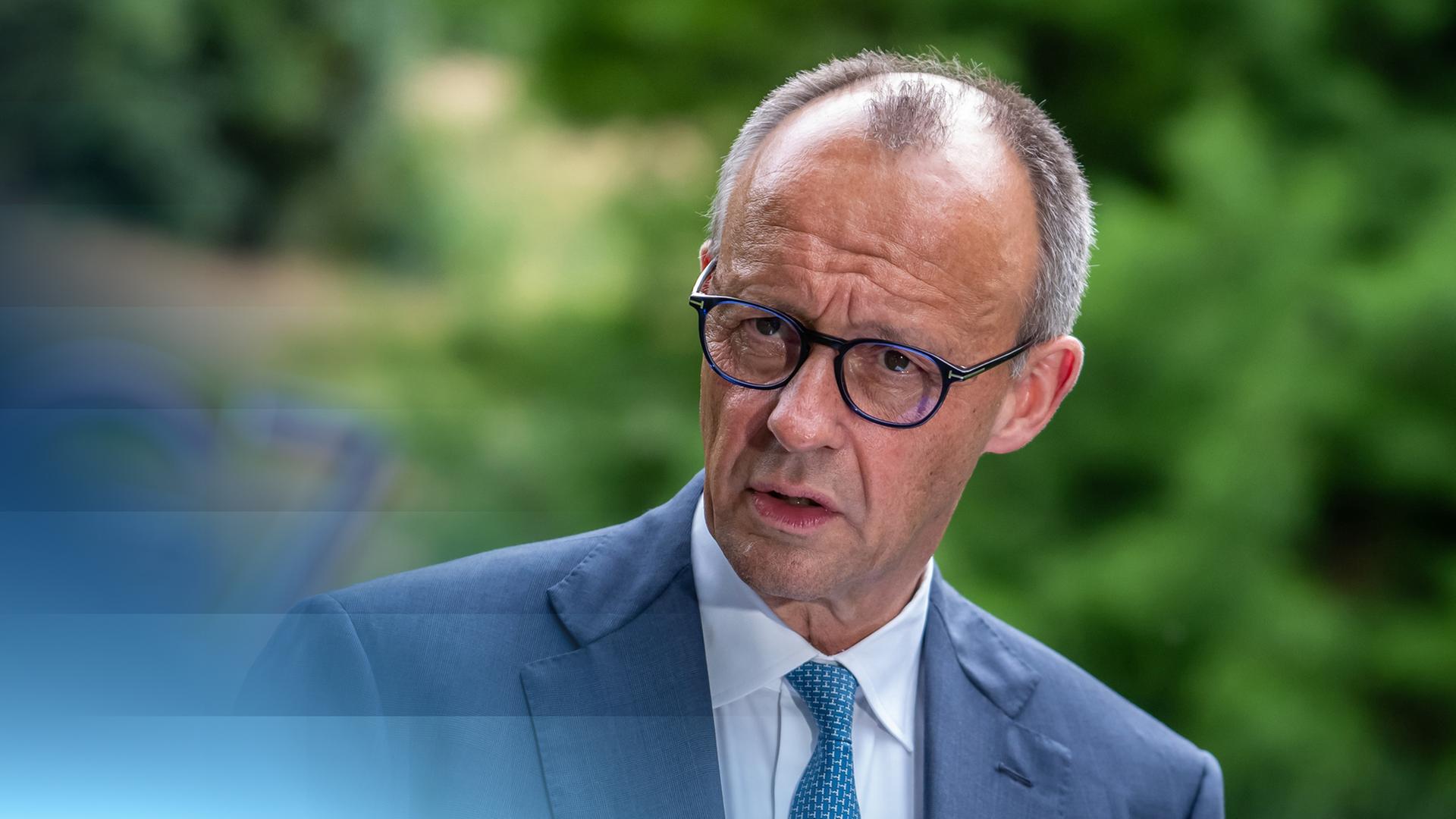 Bundeskanzler Friedrich Merz vor einem Logo der G7