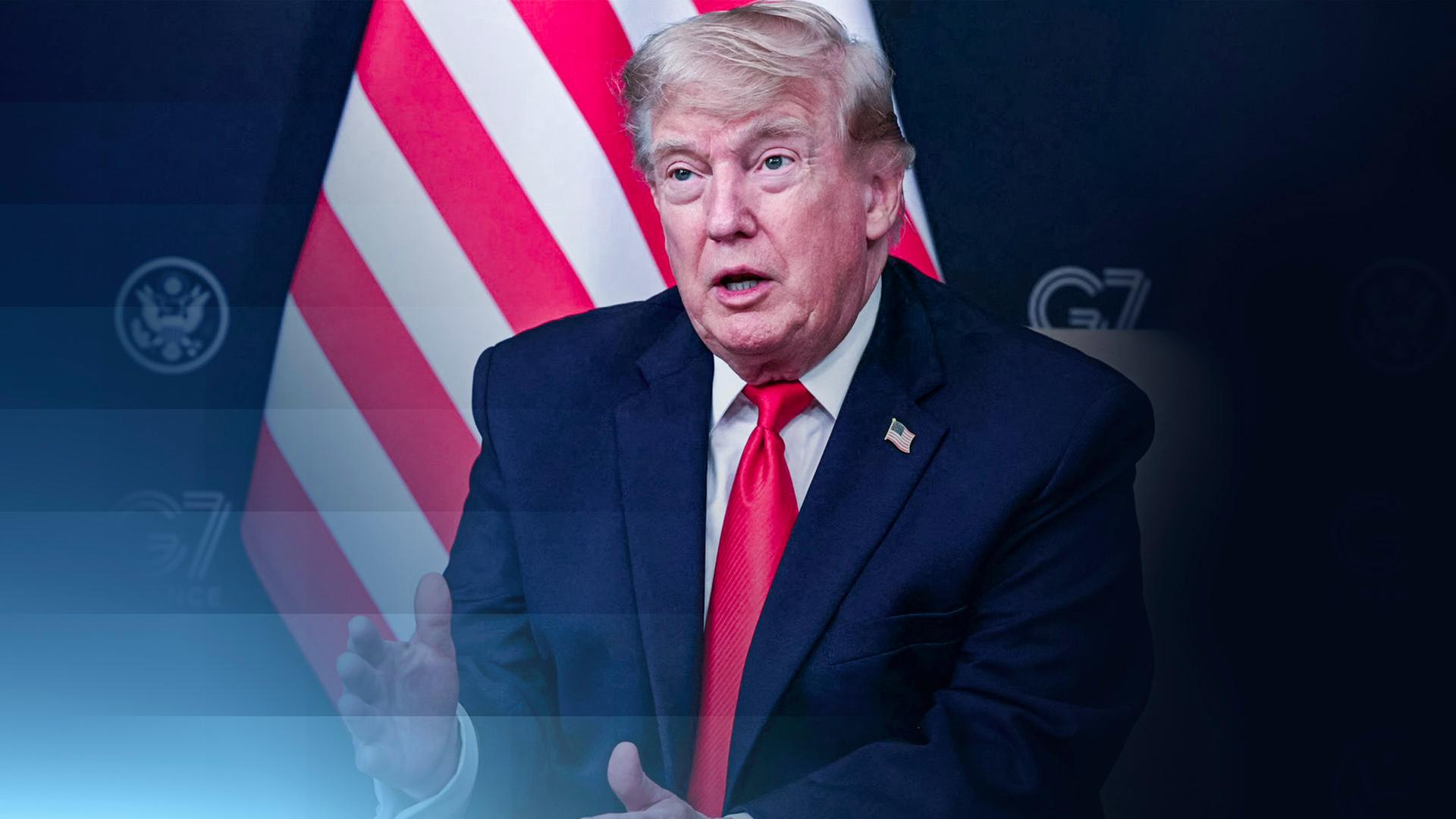US-Präsident Donald Trump sitzt vor einer US-Flagge beim G7-Treffen.