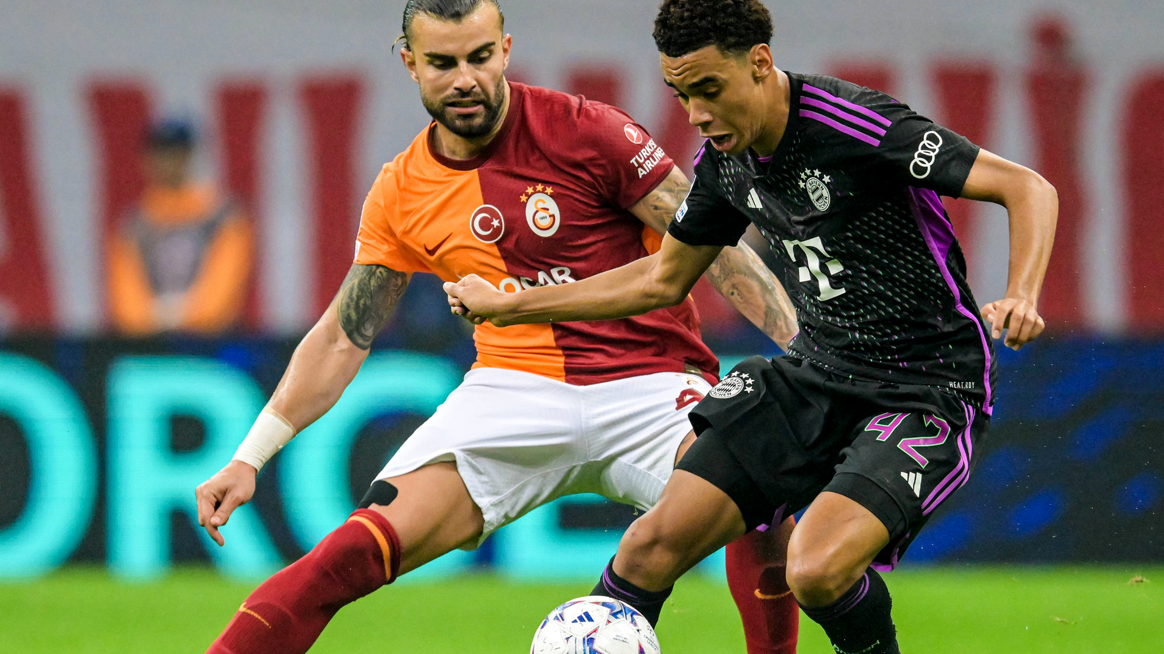 Abdulkerim Bardakci von Galatasaray und Jamal Musiala vom FC Bayern München kämpfen um den Ball.