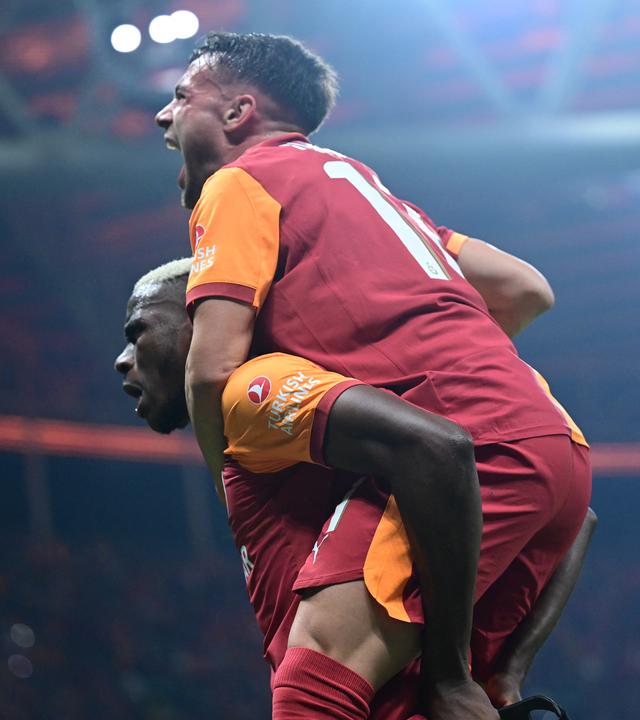 Galatasarays Torschütze Victor Osimhen nimmt einem Mitspieler huckepack und jubelt.