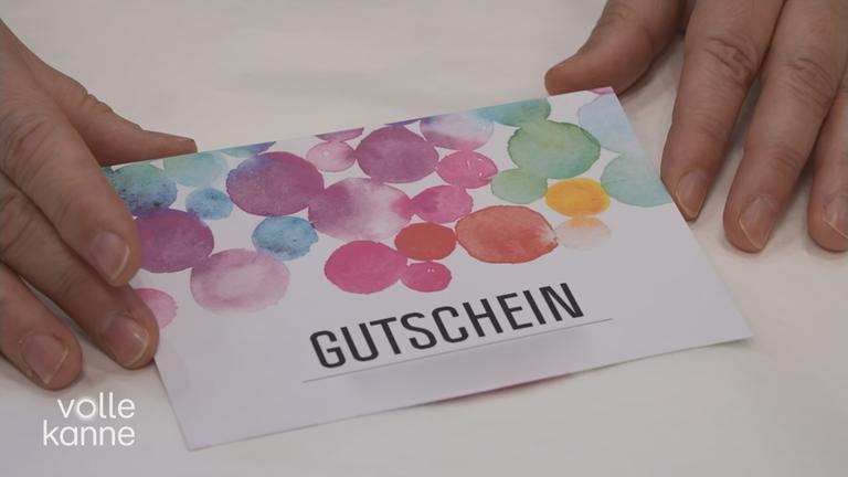 Ein bunter Gutschein auf dem Tisch.