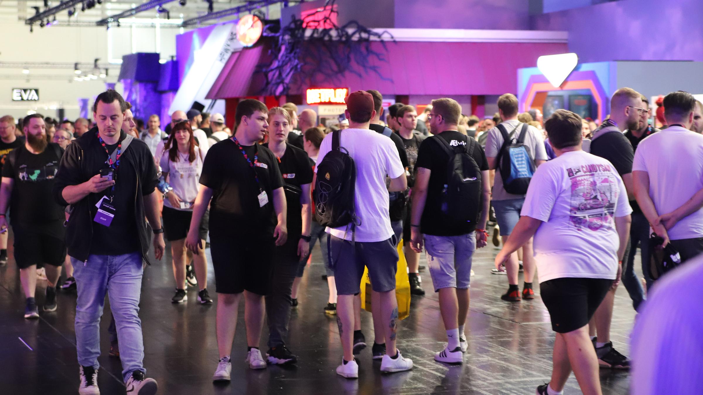 Besucher der Spielemesse Gamescom laufen durch eine der Mesehallen. 