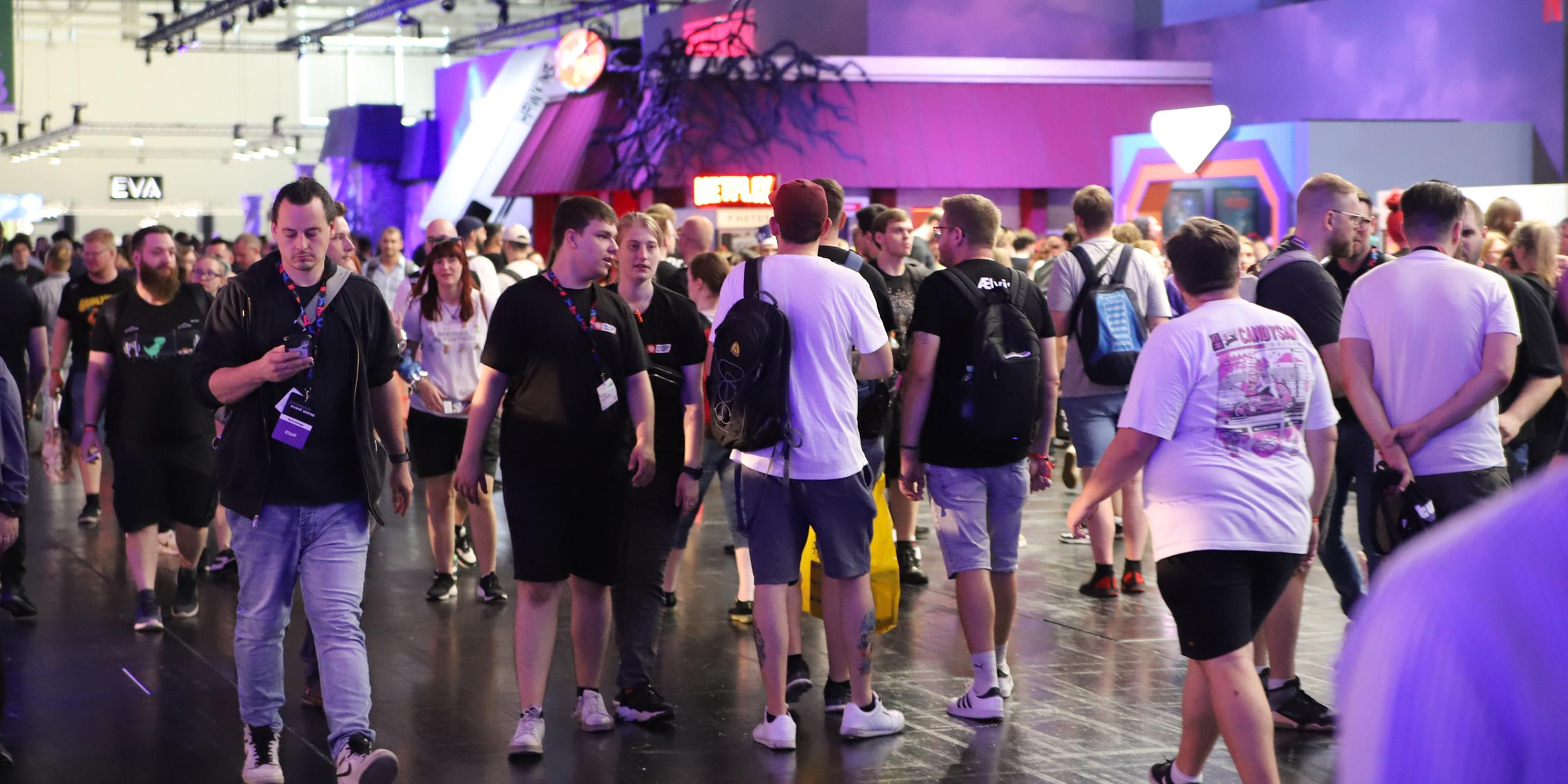 Besucher der Spielemesse Gamescom laufen durch eine der Mesehallen. 