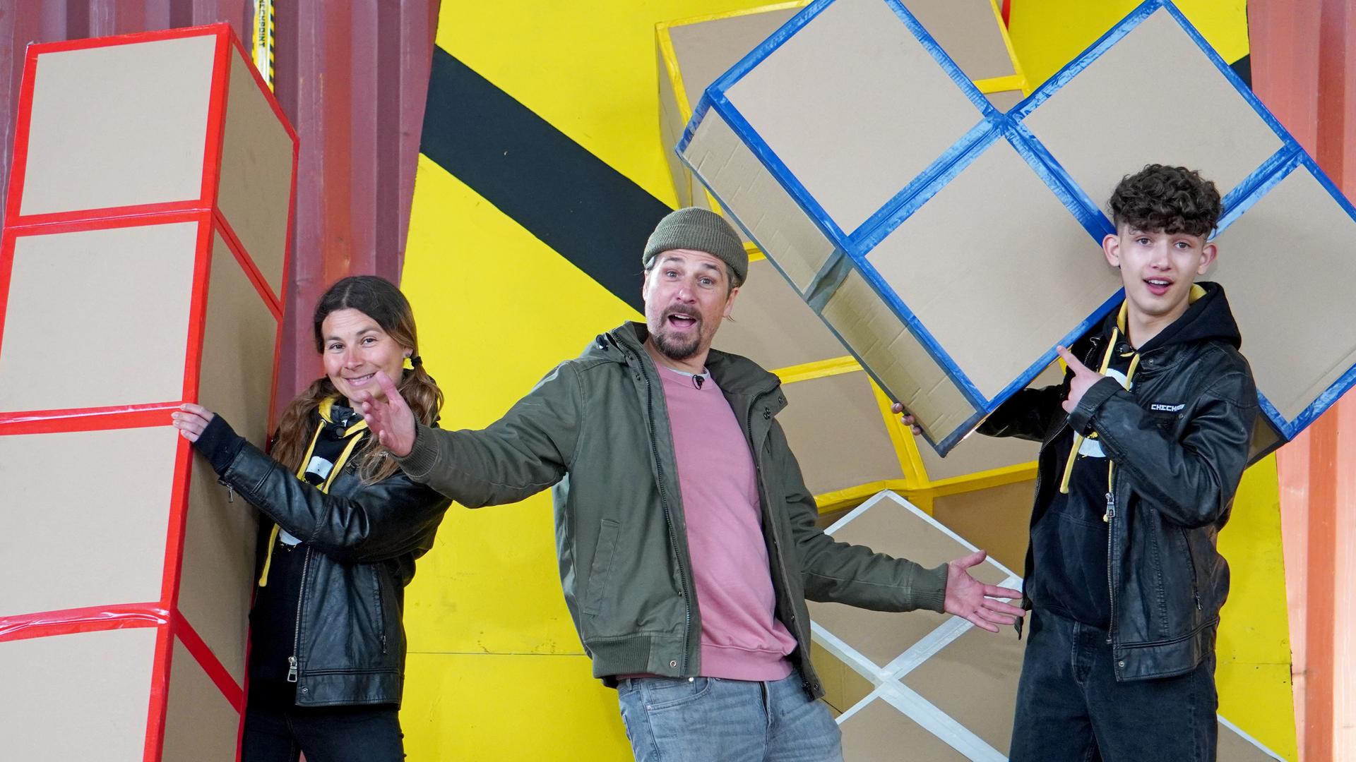 Checkpoint: Das Testteam und Tommy Schell stehen hinter einem Tisch, auf dem eine Flammenreihe aufgebaut ist. 