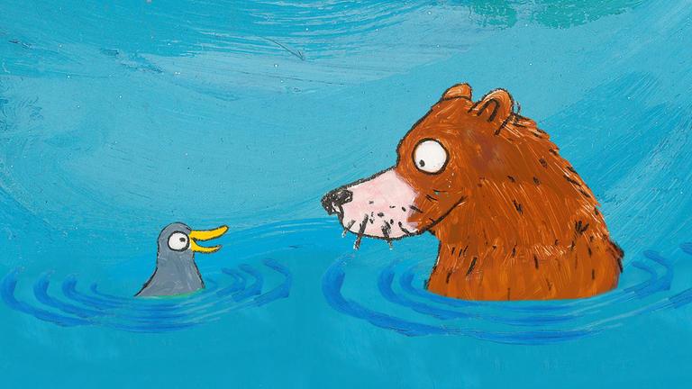 Der Bär und das Küken schwimmen im Wasser und schauen sich freudig an.