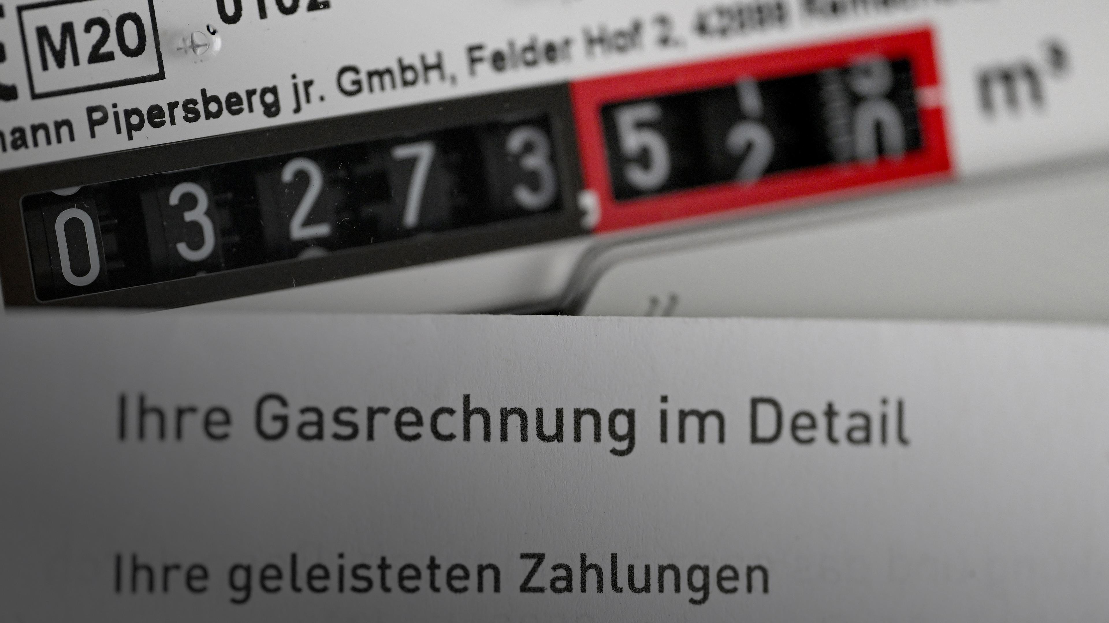 Baden-Württemberg, Stuttgart: Eine Gasrechnung wird vor einen Gaszähler in einem privaten Haushalt gehalten.