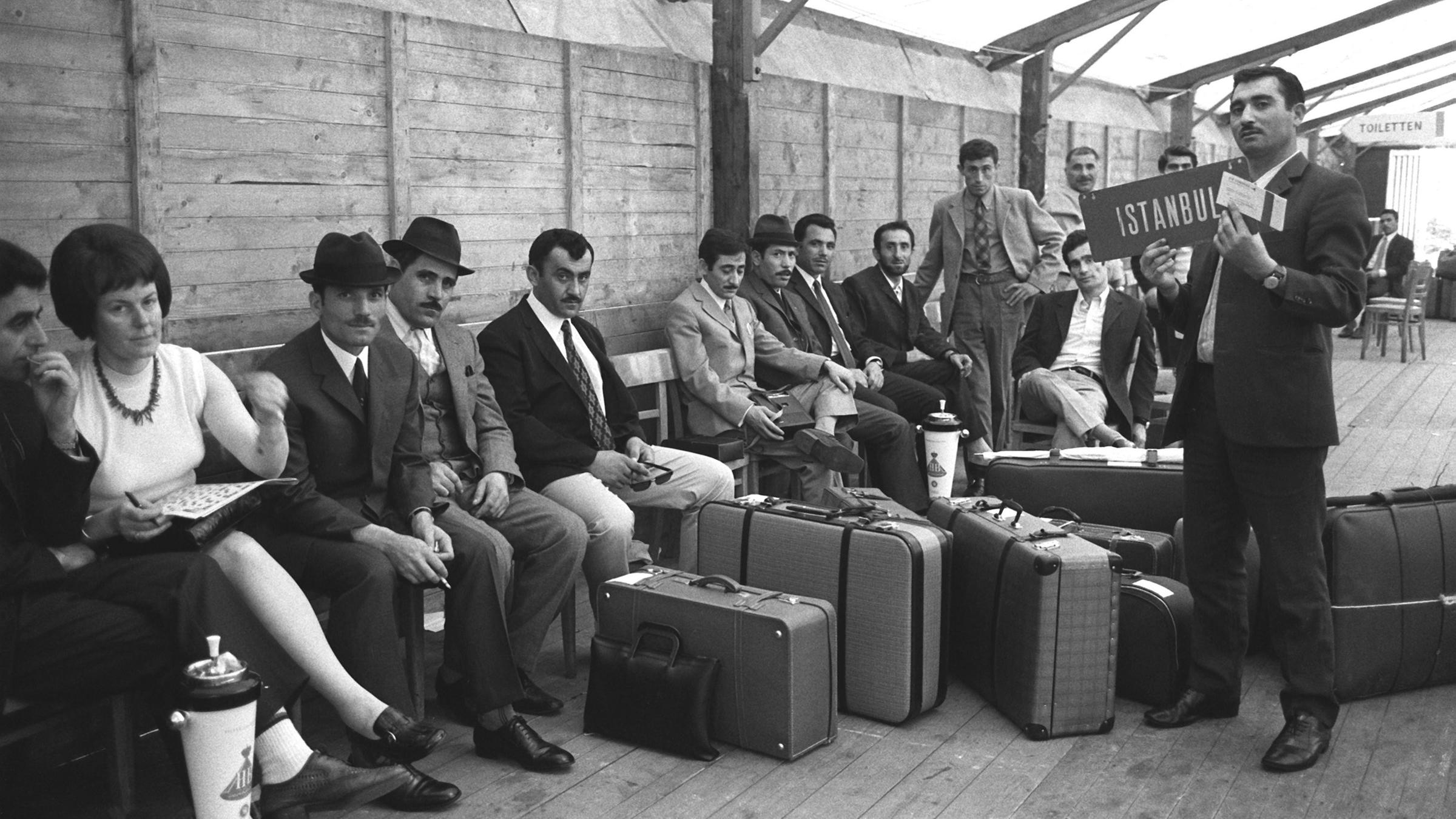 Türkische Gastarbeiter sitzen im Jahr 1970 am Flughafen Düsseldorf. (Archivbild)