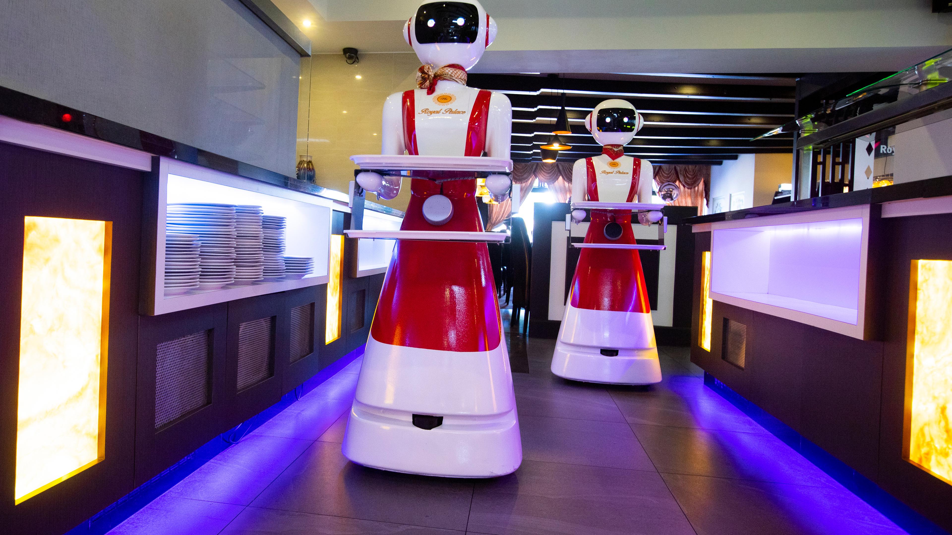 In einem Restaurant servieren Roboter auf Tablets das Essen für die Kunden