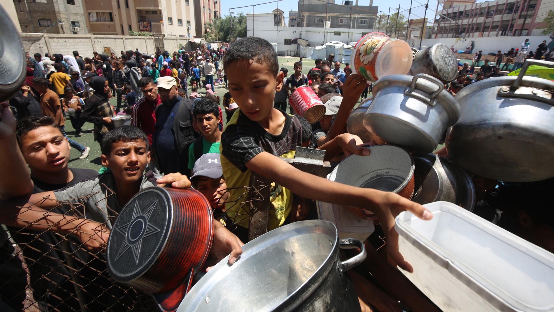 Nuseirat, Gazastreifen, Palästinensisches Gebiet: Binnenvertriebene Palästinenser versammeln sich am 30. Mai 2025 in einer Wohltätigkeitsküche im palästinensischen Flüchtlingslager Nuseirat im Zentrum des Gazastreifens, um angesichts der Nahrungsmittelknappheit begrenzte Rationen zu erhalten.