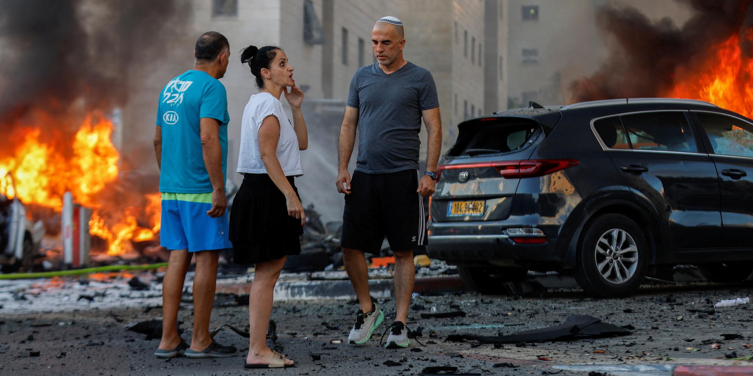 Menschen in der Nähe eines Feuers, nachdem Raketen aus dem Gazastreifen abgefeuert wurden am 07.10.2023.
