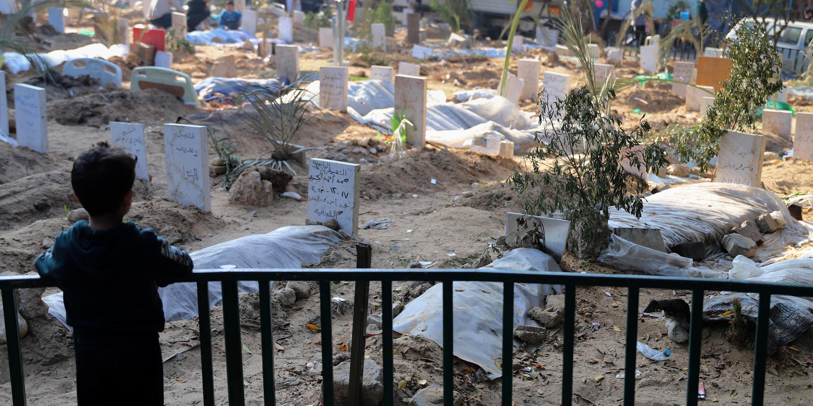  Ein palästinensisches Kind betrachtet die Gräber von Menschen, die bei der israelischen Bombardierung des Gazastreifens getötet und auf dem Gelände des Schifa-Krankenhauses in Gaza-Stadt begraben wurden.