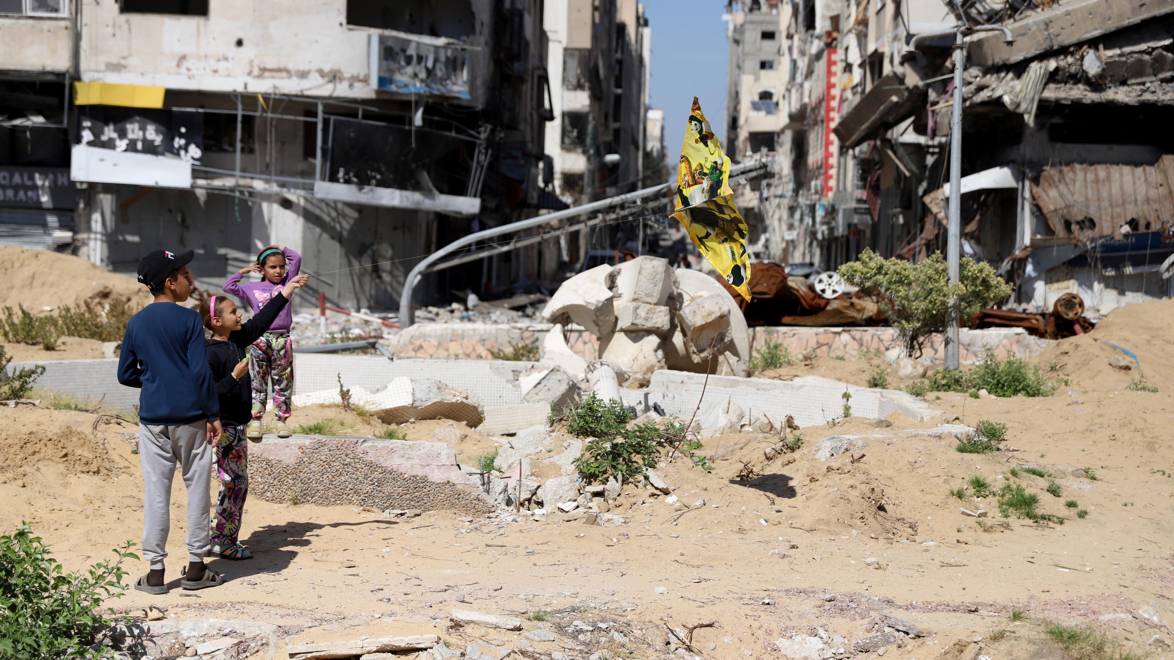 Kinder stehen in einer zerstörten Umgebung in Gazastadt.