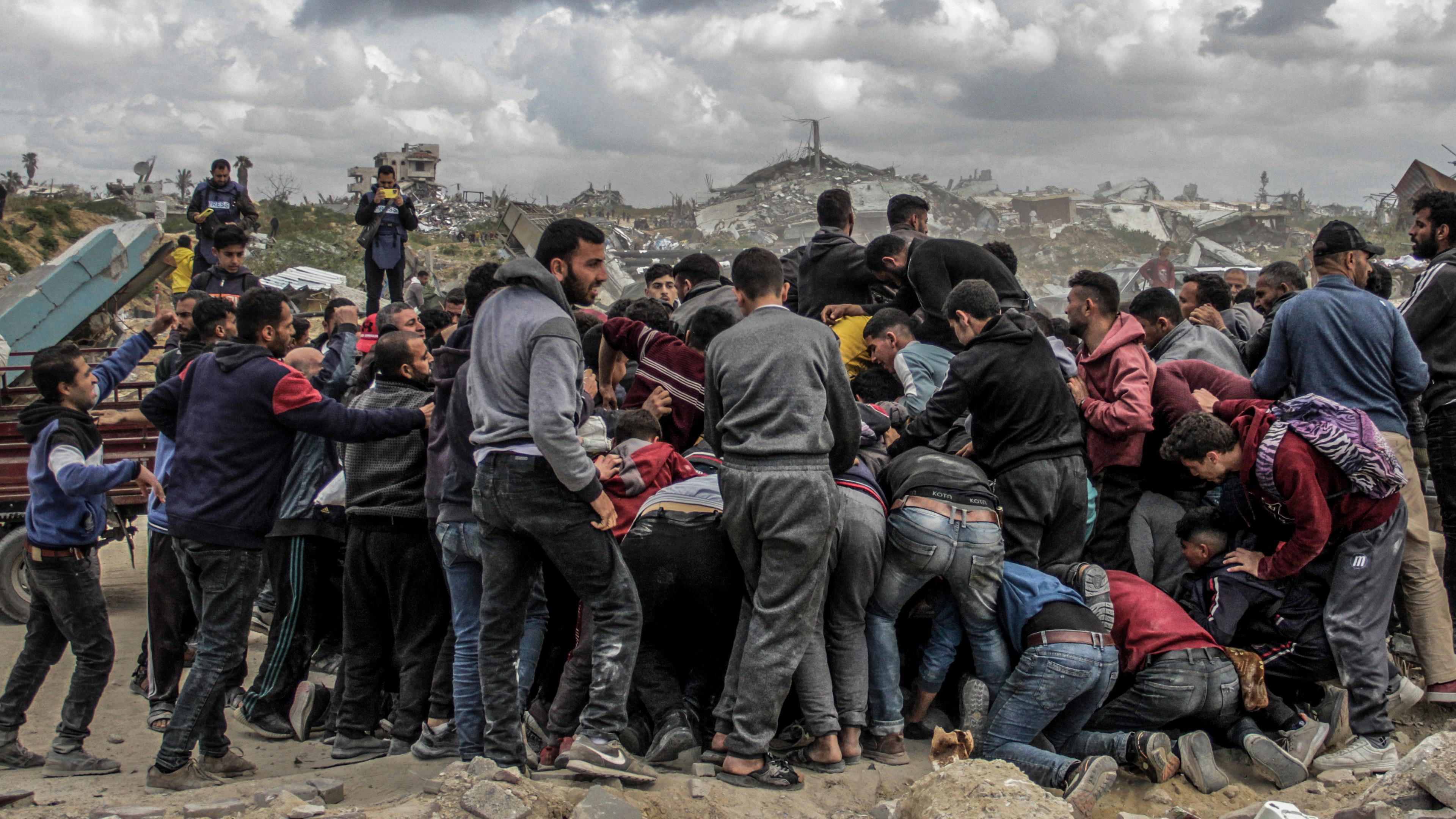 Menschen drängen sich um Pakete mit humanitärer Hilfe, die über dem nördlichen Gazastreifen abgeworfen wurden.