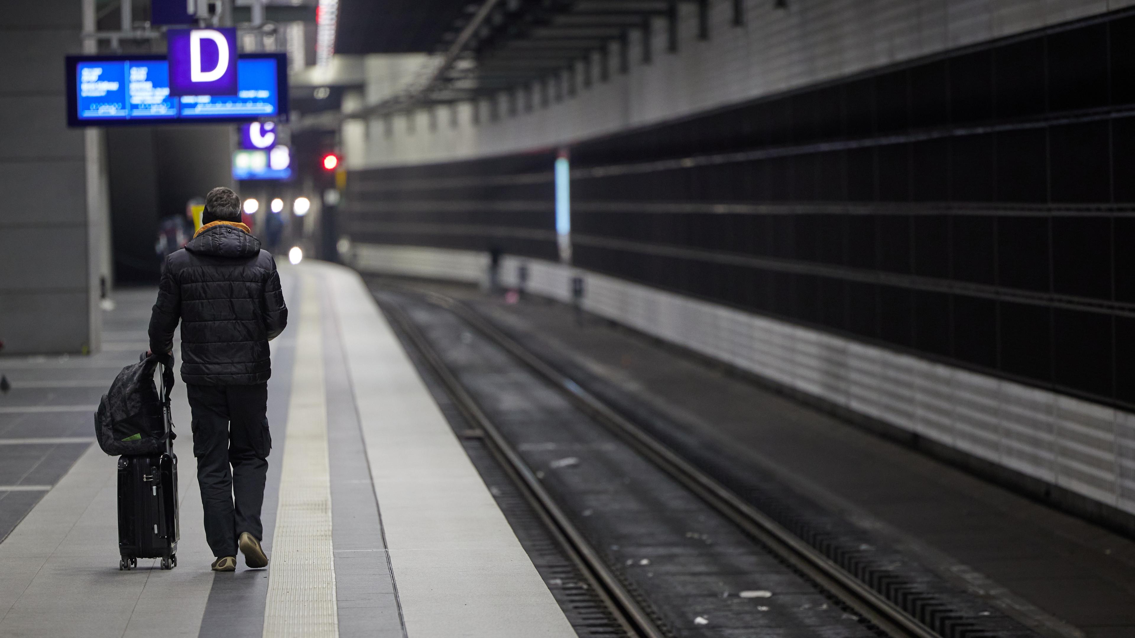 Berlin: Ein Reisender geht im Hauptbahnhof an einem leeren Gleis vorbei.