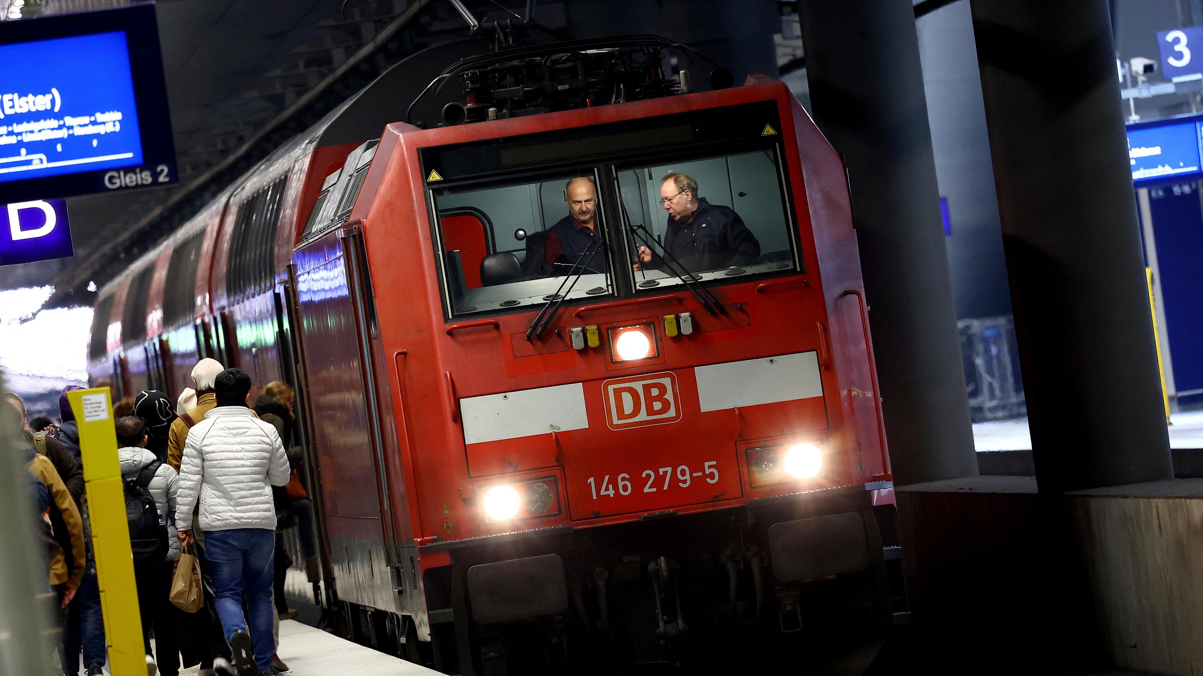 Train drivers talk in the cockpit of a train of Deutsche Bahn railway operator during shift changeover at the main station in Berlin, Germany, March 4, 2024.