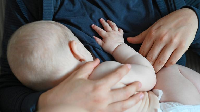 Eine Mutter stillt ihr Baby zu Hause. 
