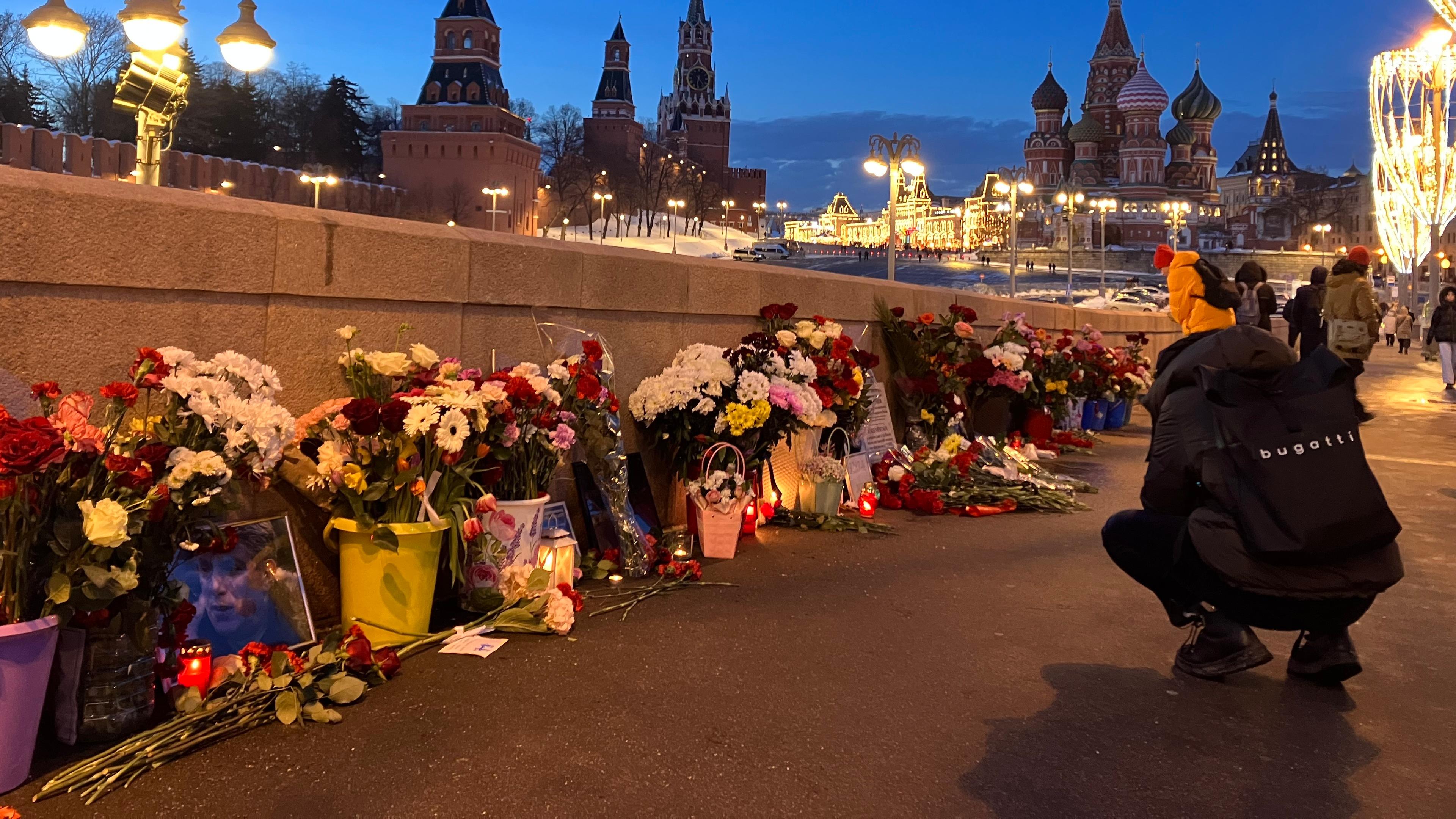 Menschen legen Blumen an der Stelle nieder, an der Boris Nemzow 2015 erschossen wurde.