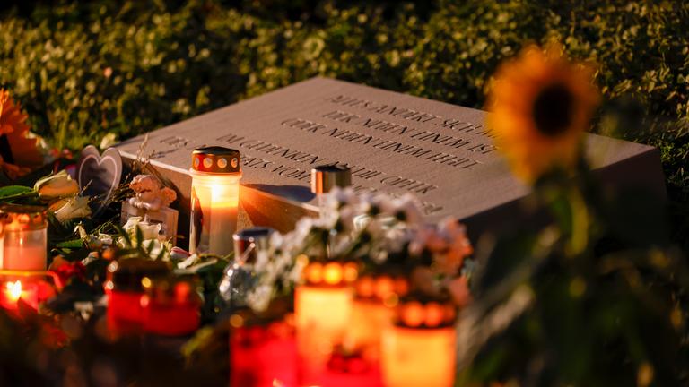 Nordrhein-Westfalen, Solingen: Weiße Rosen und Kerzen liegen am Gedenkstein für die Opfer des Terroranschlags von Solingen. Archivbild