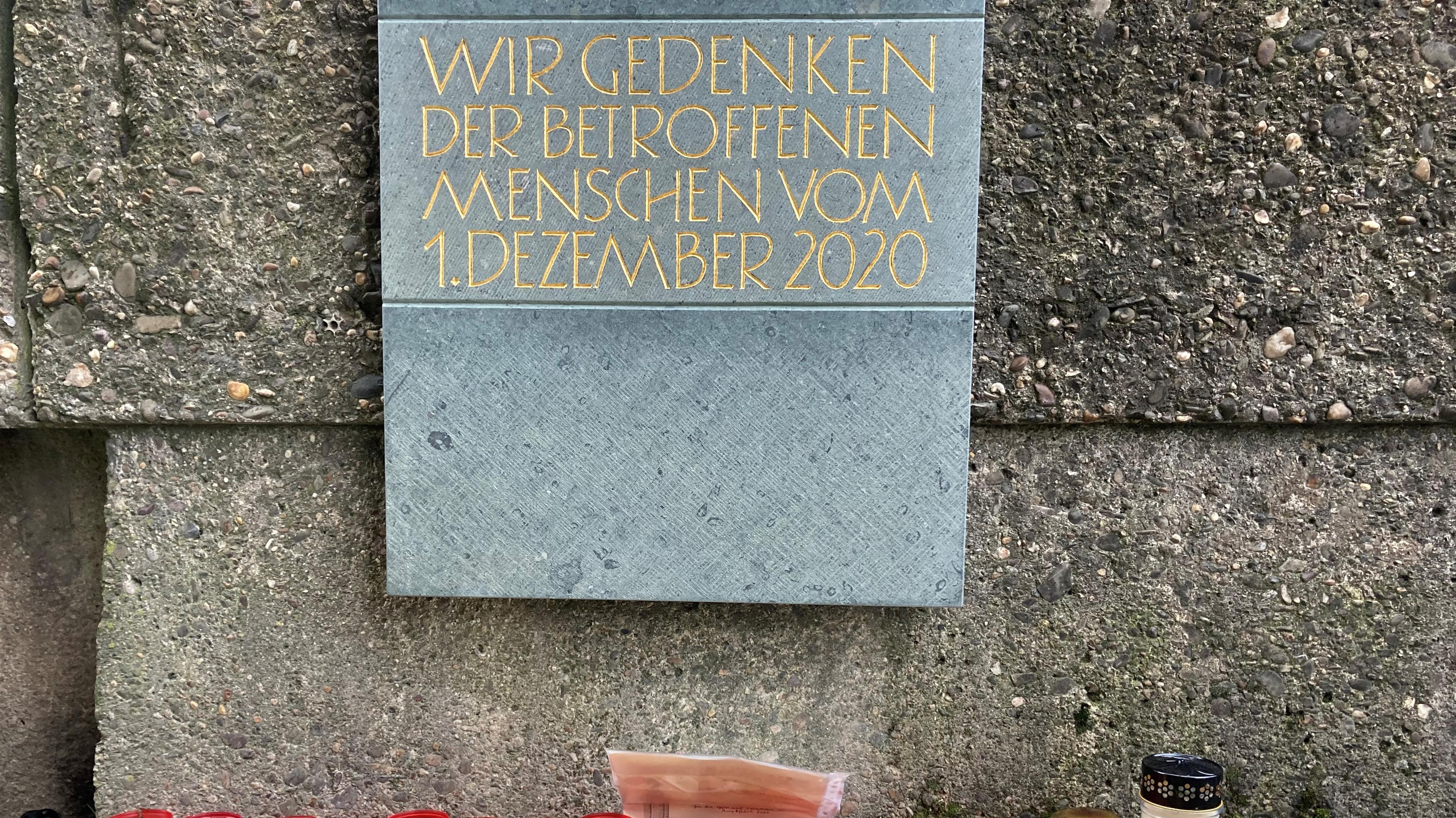 Vor einer Gedenktafel zur Amokfahrt in Trier haben Trierer Bürger Kerzen aufgestellt.