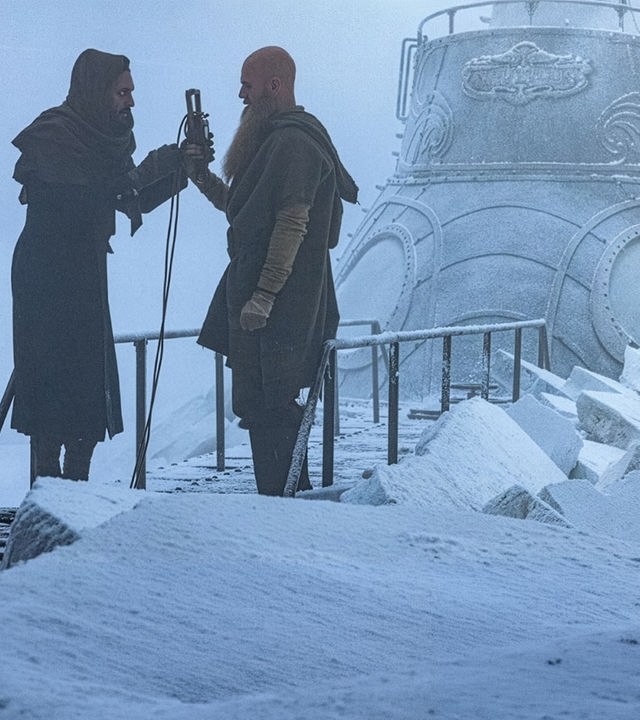 "Nautilus - Gefangen im Eis": Nemo (Shazad Latif) und Jiacomo (Andrew Shaw) stehen sich auf dem vereisten U-Boot Nautilus gegenüber. Nemo übergibt Jiacomo einen Gegenstand, an dem ein langes Kabel befestigt ist.