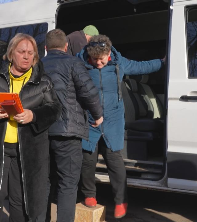 Ukrainer*innen steigen aus einem Bus am Grenzübergang 