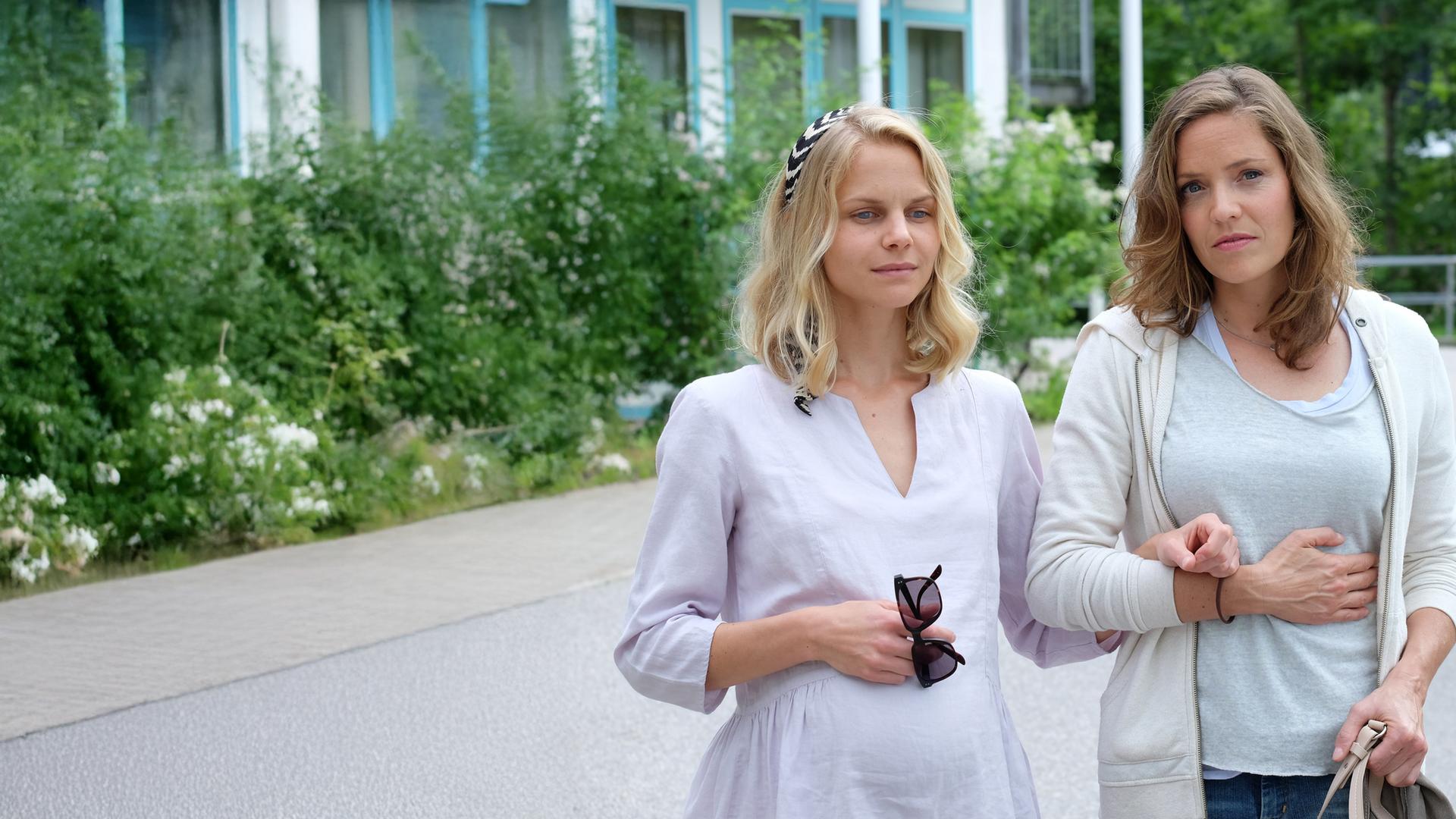 "Lena Lorenz - Gegen alle Zweifel": Lena Lorenz (Patricia Aulitzky) geht mit der sehbehinderten und hochschwangeren Annette Bering (Sinja Dieks) die Krankenhausauffahrt entlang.