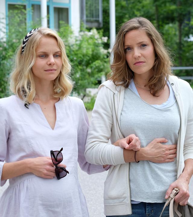 "Lena Lorenz - Gegen alle Zweifel": Lena Lorenz (Patricia Aulitzky) geht mit der sehbehinderten und hochschwangeren Annette Bering (Sinja Dieks) die Krankenhausauffahrt entlang.
