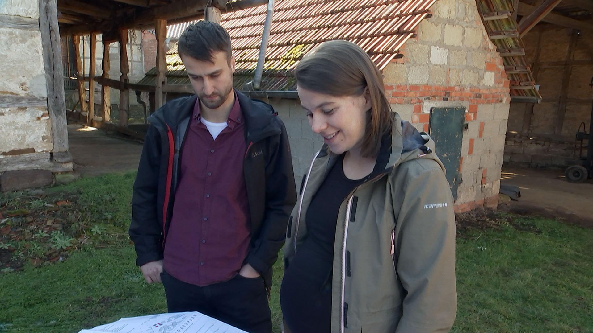 Junges Paar steht vor einem alten Haus in einem Dorf in Unterfranken
