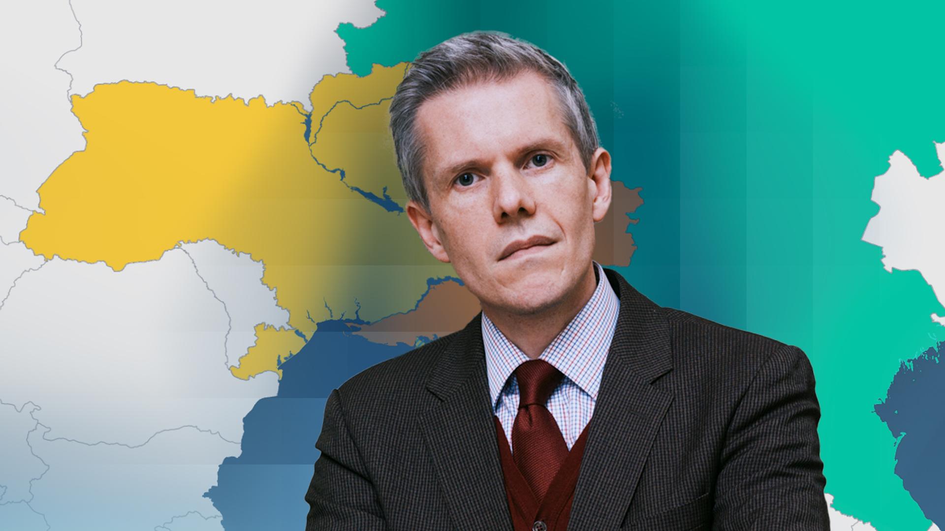 Militärökonom Marcus M. Keupp vor einer Karte der Ukraine und Russland.