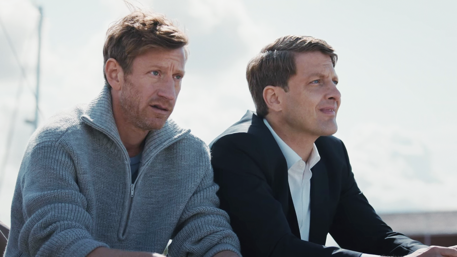 Henk Cassens (Maxim Mehmet) und Wolfgang Habedank (Holger Stockhaus) sitzen am Hafen nebeneinander. 
