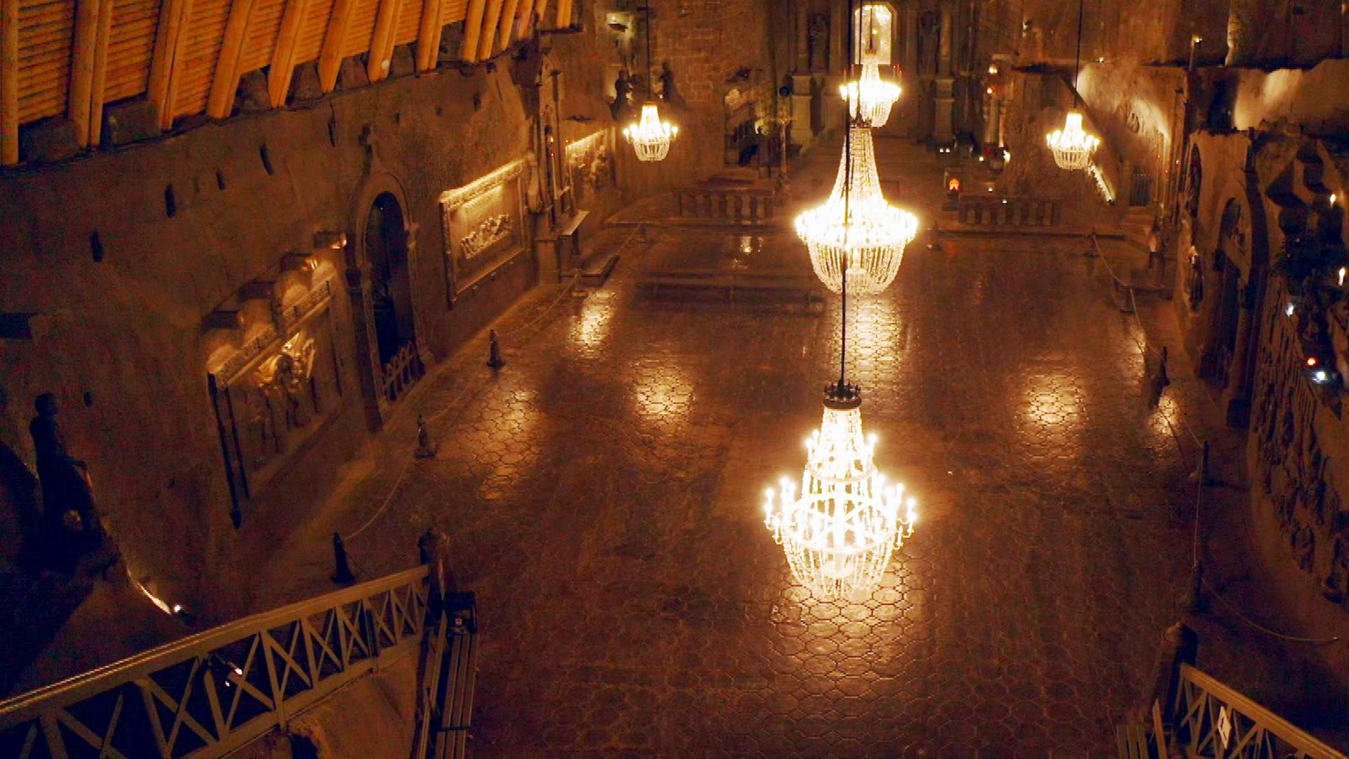 Geheime Welten - Reise in die Tiefe: Kathedralen der Unterwelt":  Dunkler Raum, in dem fünf große Kronleuchter von der Decke hängen.