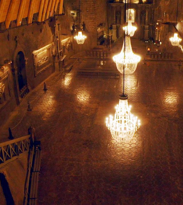 Geheime Welten - Reise in die Tiefe: Kathedralen der Unterwelt":  Dunkler Raum, in dem fünf große Kronleuchter von der Decke hängen.