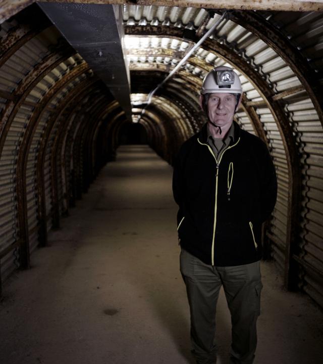 "Geheime Welten - Reise in die Tiefe: Verborgene Stollen": Mann mit Helm und Helmlampe steht in einem langen Tunnel. Der Tunnel hat ein Tonnendach.