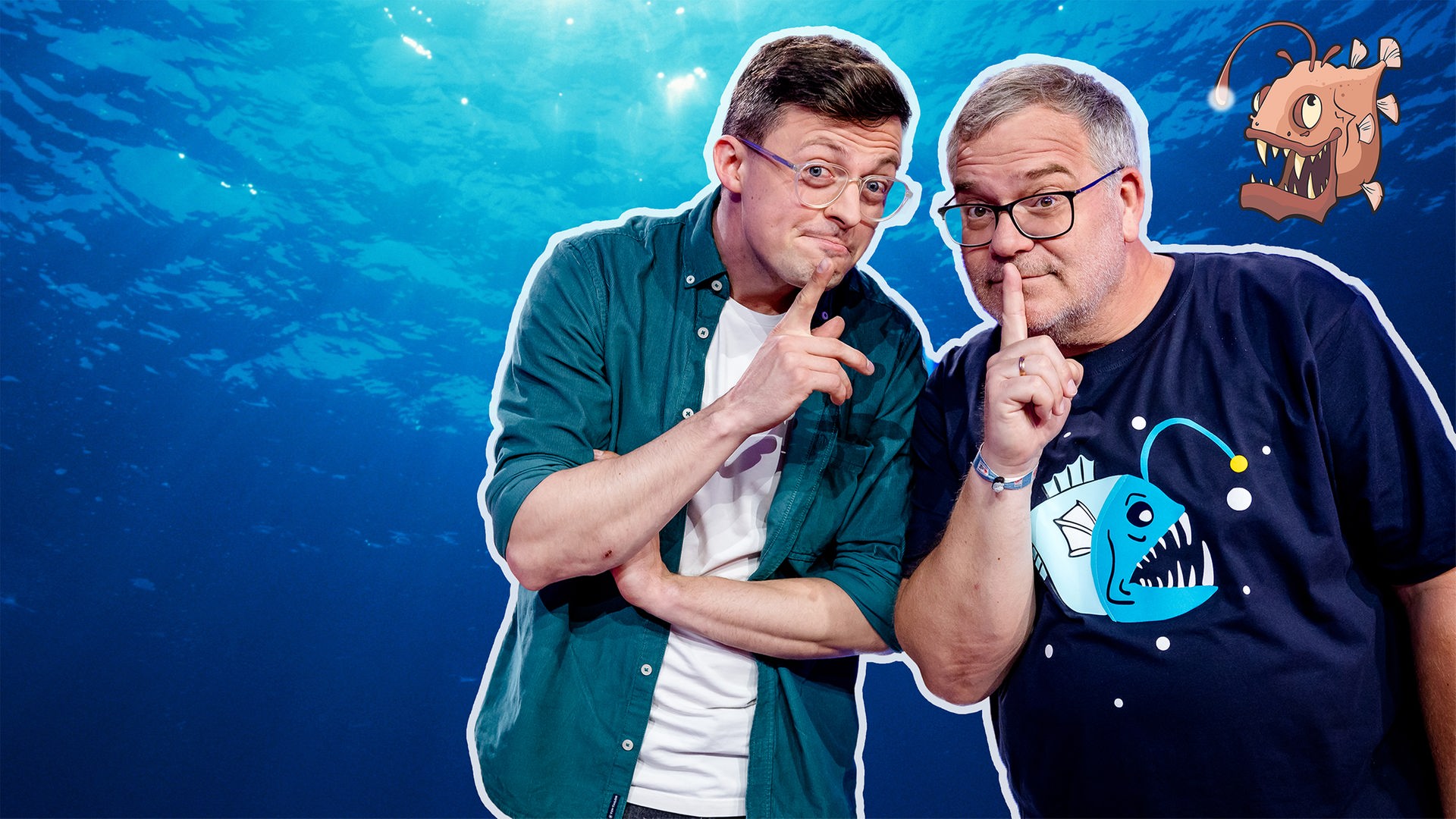 Vor einem blau schimmernden Hintergrund, der an die Tiefsee erinnert, posieren Jacob Beautemps und Elton dicht nebeneinander. Sie schauen in die Kamera und halten jeweils einen Finger an den Mund. Im rechten oberen Bereich des Bildes ist eine illustrierte, bedrohlich wirkende Meereskreatur mit leuchtendem Köder zu sehen.