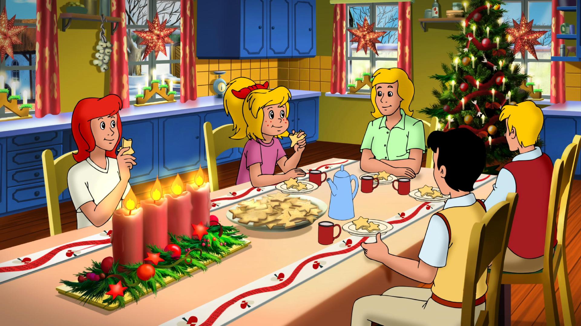 Bibi und Tina und ihre Familie und Freunde sitzen gemeinsam am Tisch und essen Plätzchen. Der Raum ist weihnachtlich geschmückt und im Hintergrund steht ein großer, funkelnder Weihnachtsbaum.