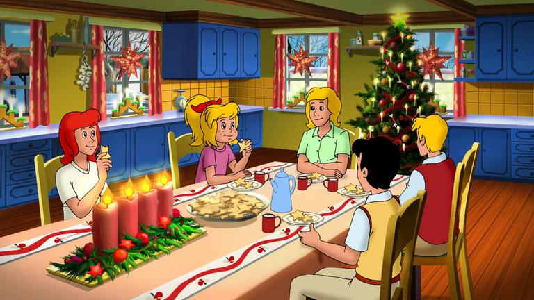 Bibi und Tina und ihre Familie und Freunde sitzen gemeinsam am Tisch und essen Plätzchen. Der Raum ist weihnachtlich geschmückt und im Hintergrund steht ein großer, funkelnder Weihnachtsbaum.