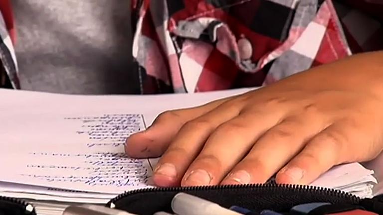 Eine Hand deckt eine Seite einer Vokabelliste zu.