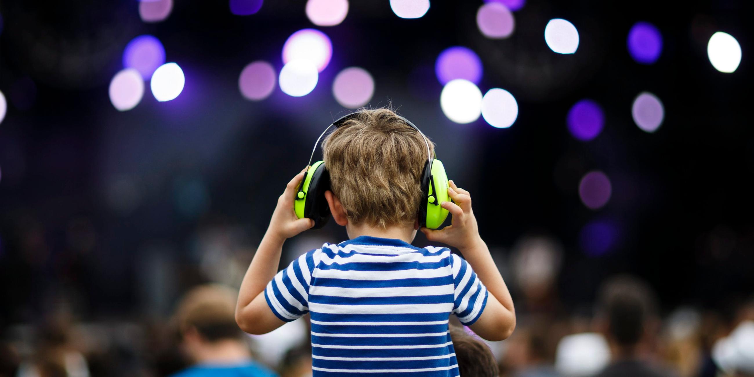 Ein Kind trägt auf einem Konzert Over-Ear-Kopfhörer.