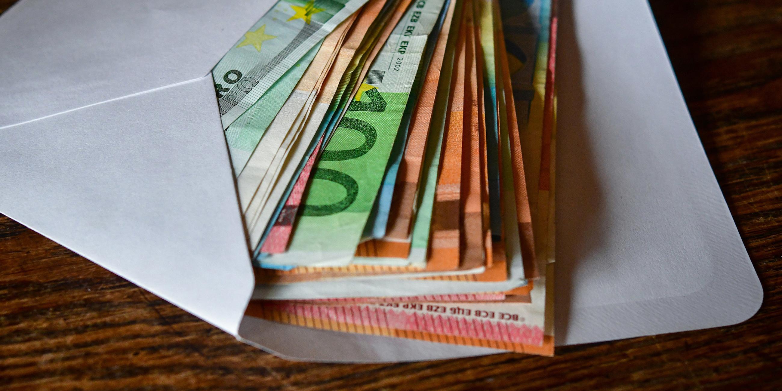 Brandenburg, Sieversdorf: Viele Eurobanknoten liegen in einem Briefumschlag auf einem Tisch. 