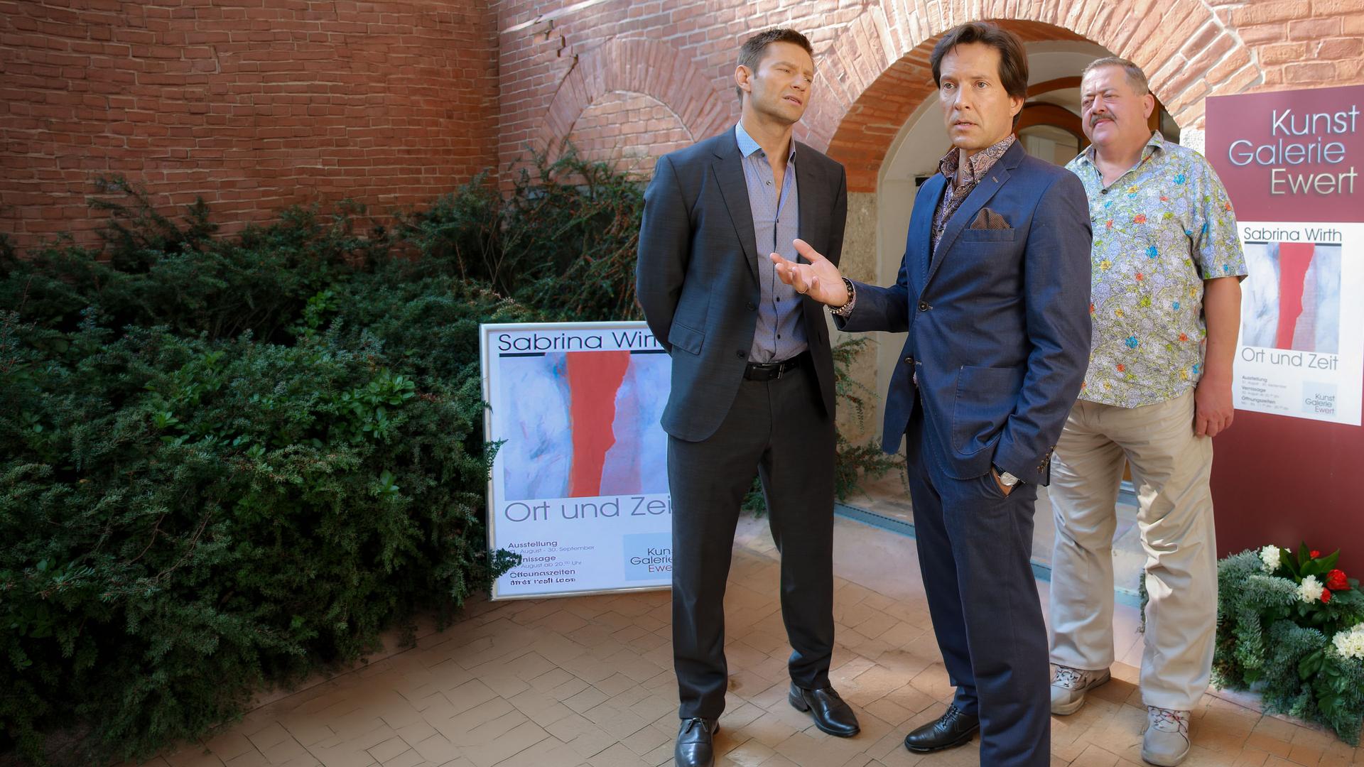 "Die Rosenheim-Cops - Geld ist tödlich": Die Kommissare Hansen (Igor Jeftic) und Hofer (Joseph Hannesschläger) stehen mit Marcel Ewert (Christof Arnold) in den Räumen einer Kunstgalerie.