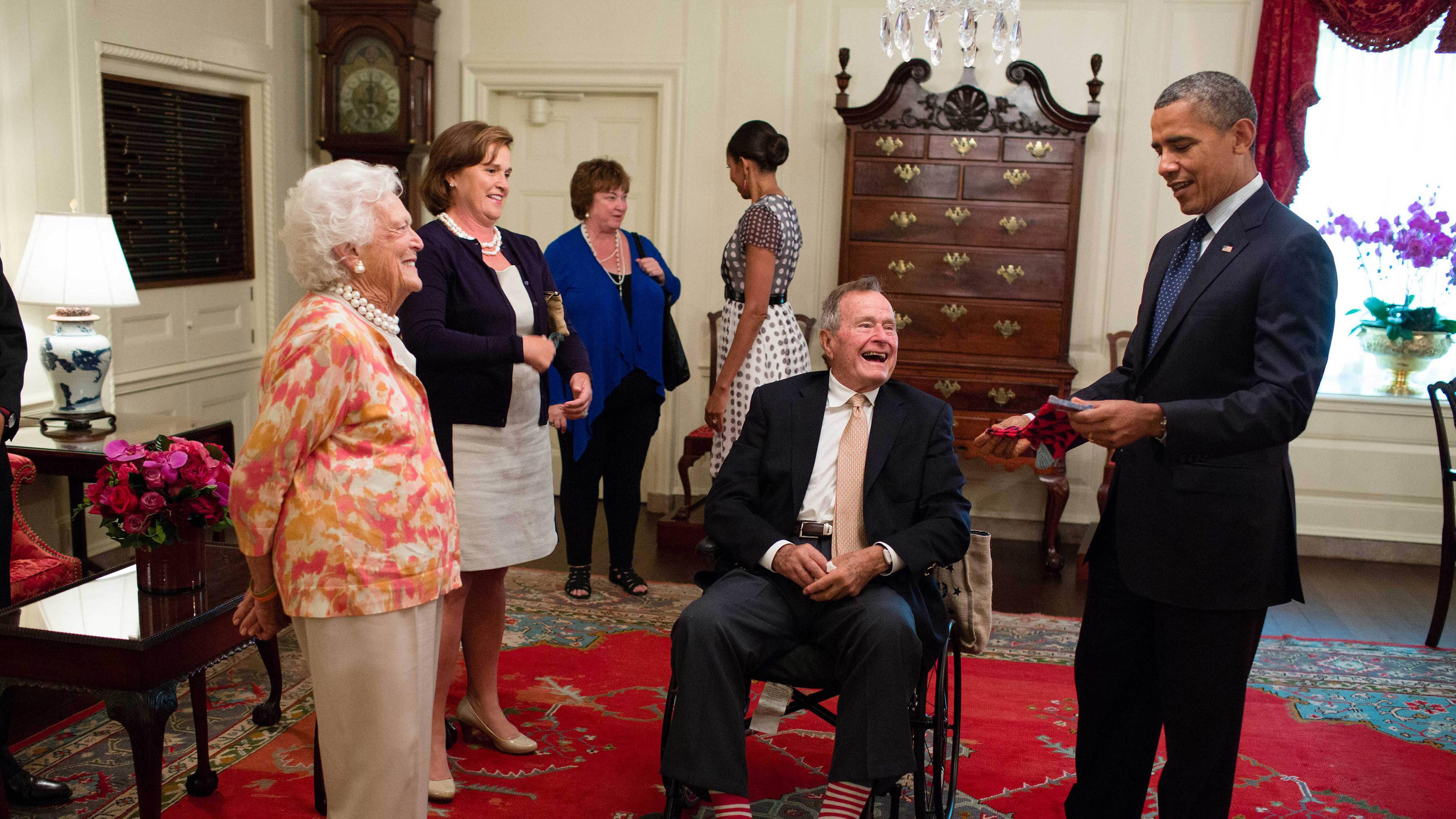 George H.W. Bush und seine Frau schenken Präsident Barak Obama am 5. Juli 2013 ein paar bunte Socken