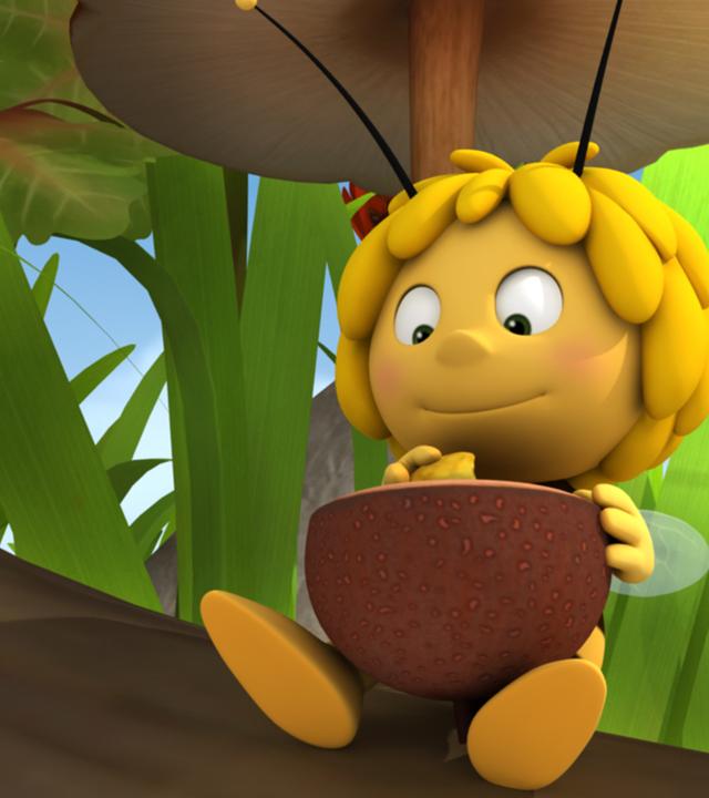 Maja lässt sich den Blütenpollennektar schmecken. Sie sitzt auf einem Ast und grinst die Polle an.