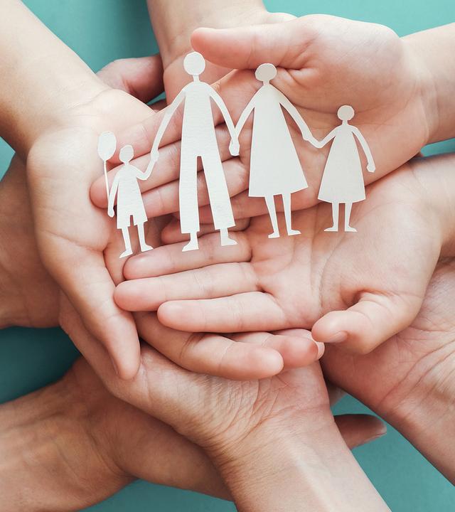Familie legt Hände ineinander. Hände groß im Bild.