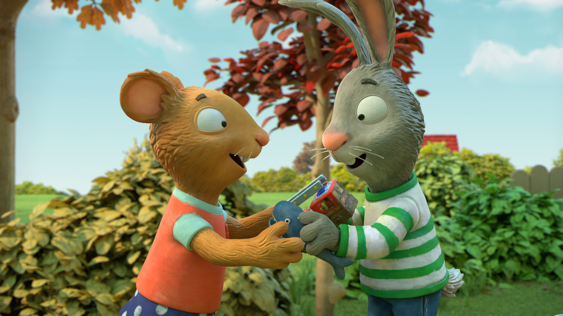 Draußen im Grünen: Die Maus Posy und ihr Freund Pip, das Kaninchen, stehen sich gegenüber. Sie halten ihre Hände aneinander. In Posys linker Hand befindet sich ein Feuerwehrauto und in Pips rechter Hand ein kleiner Hai. Sie lächeln beide erwartungsvoll und freudig. Im Hintergrund sind Sträucher zu sehen.