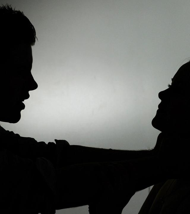 Zwei schwarze Silhouetten: Ein Mann würgt eine Frau